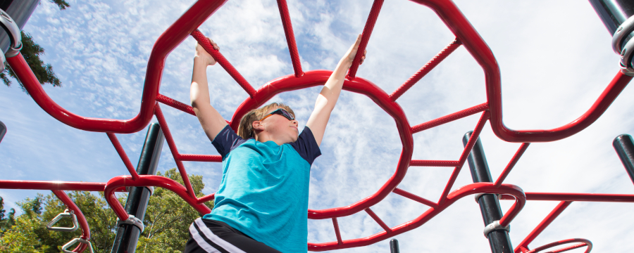 Young boy playing on an overhead climber