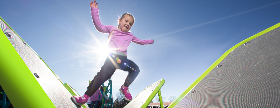 Girl jumping across Miracle's Champions Trek Breakaways