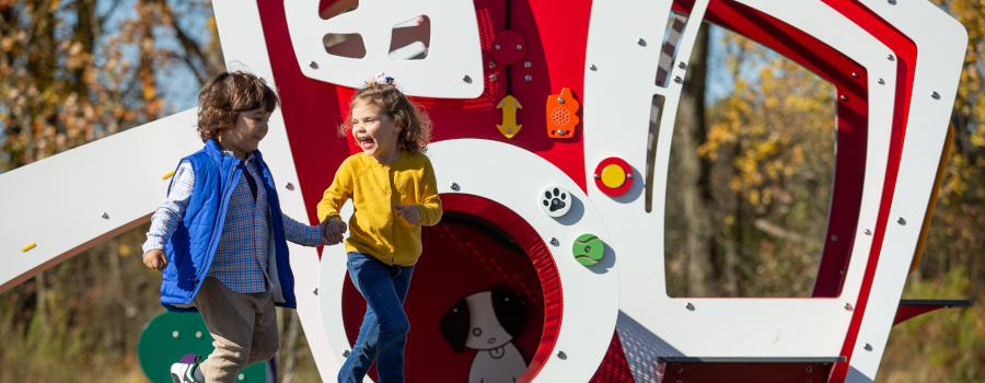 Children walking across a playground holding hands