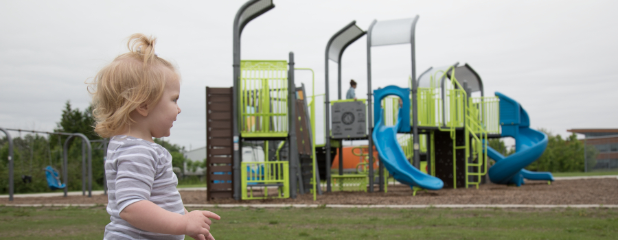 Young girl looking at a playground in the distance
